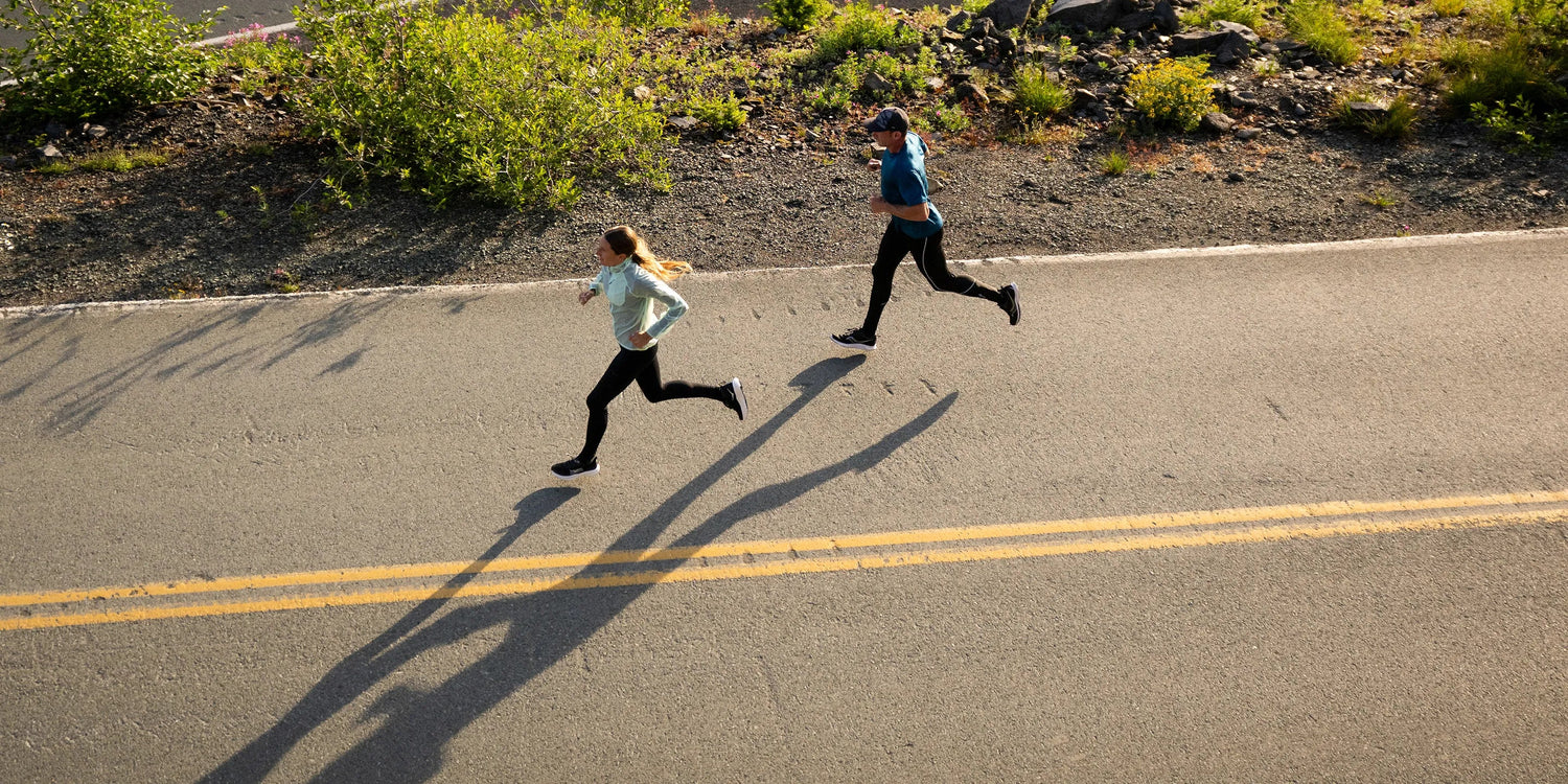Man and Woman running on road wearing Superfeet active insoles.